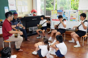  地域から招いた講師から三味線の弾き方を学ぶ児童たち＝９日、瀬戸内町の嘉鉄小