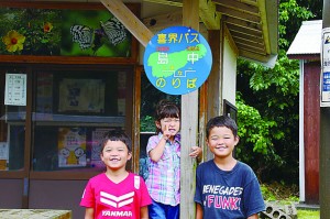 子どもたちも興味津々。島ゆみた表示板のあるバス停＝６月２９日、喜界町島中