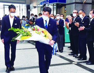 県職員に出迎えられ登庁する塩田知事＝２８日、鹿児島市の県庁