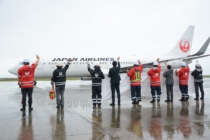 羽田へ向かう航空機に手を振って見送るＪＡＬの職員＝１日、奄美空港