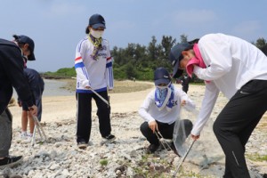 ごみ拾いに汗を流す喜界高校の生徒ら＝７月３１日、喜界町の池治海水浴場