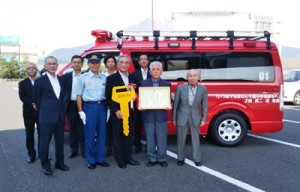 奄美市へ消防指揮車を寄贈した才納さん（右から２人目）＝５日、鹿児島市（同市提供）