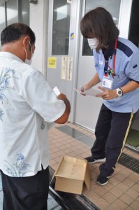 選挙用はがきを郵便局員に預ける候補者（左）＝２５日、与論町茶花