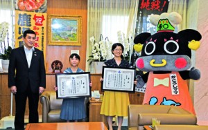 和牛能力共進会鹿児島大会のマスコットキャラクター「かごうしママ」と本村さん、濵島さん（右から）＝２８日、鹿児島市の県庁