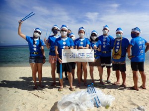 青いサンタの格好で海岸のごみ拾いを行った参加者＝７月２４日、知名町（提供写真）