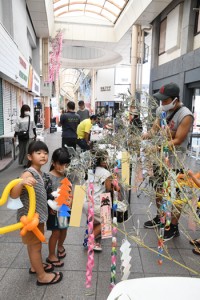 多くの親子連れが足を運んだ七夕の笹飾りつけブース＝１５日、奄美市名瀬