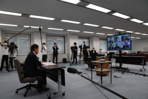 テレビ会議で新型コロナ対策への取り組みを説明する塩田知事（左）＝８日、鹿児島市の県庁