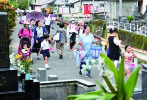 送り盆の墓参りに訪れた人々＝２日、奄美市名瀬の永田墓地