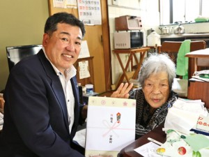 元山村長から記念品を受け取る友さん（右）＝１７日、宇検村湯湾