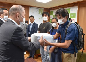 鎌田町長に署名を提出する髙木氏（右）＝３０日、瀬戸内町