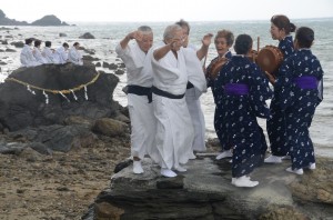 小雨が降る中、海のかなたのネリヤカナヤの神々に祈りをささげる平瀬マンカイ＝２０日、龍郷町秋名