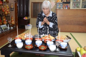 ツカリの日に、赤飯などの料理を供え、コウソガナシに祈願する肥後サツさん＝１９日、龍郷町秋名