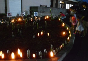 高齢者の長寿を祝い、県道沿いの花壇などに飾られた竹灯籠＝２１日、知名町田皆