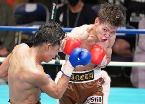 負傷しながらもパンチを繰り出す峯田選手＝２日、東京・後楽園ホール