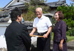 町職員から祝い状を受け取る金婚夫婦＝６日、伊仙町面縄