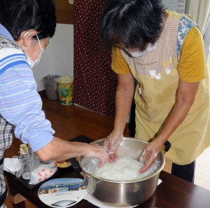 材料を入れてかき混ぜ、ミキを仕込む実久集落の住民＝２３日、瀬戸内町実久