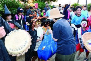 踊りを終え餅やお菓子を受け取る仮装した子どもたち＝１０月３１日、伊仙町阿権