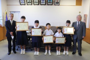 最優秀賞を受賞した坂本さん（左から２人目）と優秀賞に選ばれた児童ら＝１７日、喜界町役場