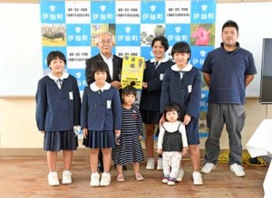 大久保町長から子育て世帯応援給付金の目録を受け取る池上さん一家＝１３日、伊仙町伊仙