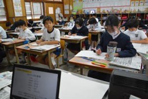 熱心にメモを取りながら新聞社の働きについて学ぶ児童＝１７日、瀬戸内町の古仁屋小学校