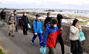 海岸沿いのサイクリングロードを歩く奄美トレイル開通記念ウオークの参加者＝２０日、奄美市笠利町