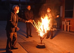 復帰運動時を再現したかがり火の前で当時の様子などを語り合う参加者＝２５日、奄美市名瀬