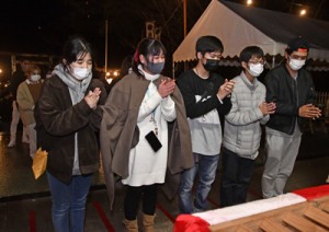 高千穂神社の拝殿で静かに手を合わせる参拝者＝１日、午前０時ごろ、奄美市名瀬 　