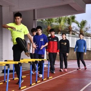 地元の中学生らと一緒にトレーニングに励む選手たち＝１１日、奄美市の名瀬運動公園陸上競技場