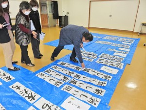 寄せられた作品を入念に確認する審査員＝１８日、龍郷町のりゅうがく館（提供写真）