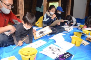 田中一村終焉の地で絵筆を握る一村キッズクラブの児童たち＝１７日、奄美市名瀬有屋町