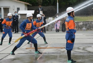 操法訓練を披露する知名町消防団の団員＝６日、知名漁港