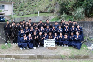 創立１０周年を記念し、植樹されたスモモの木の成長を願う大和中学校の全校生徒たち＝２０２０年１２月２３日(大和中学校提供) 