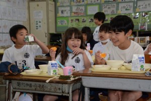 提供されたタンカンを頬張る児童＝１７日、奄美市名瀬の奄美小学校