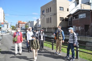 西條さん（右から２番目）の案内で市街地を散策する参加者ら＝２０日、奄美市名瀬