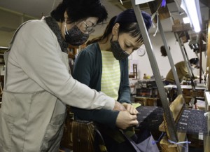 機織りの指導を行う伝統工芸士の平さん（左）と受講生の石川さん＝１月２３日、龍郷町大勝の夢おりの郷