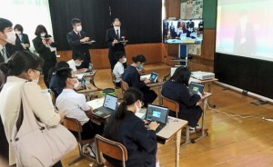 ＩＣＴ機器を活用した遠隔合同授業の様子を見学する参加者ら＝９日、徳之島町母間