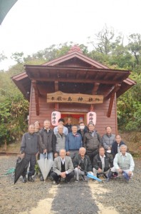 集落民で協力して建て替えた厳島神社の社殿と住民＝１１日、奄美市笠利町外金久