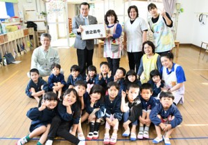  徳之島町で生産、肥育された牛肉を受け取る母間保育所の園児と職員＝１８日、同町母間