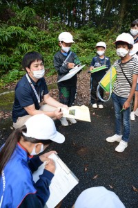 篠川小中学校の児童生徒に三太郎峠のフィールドワークで動植物の開設をする平城さん＝２０２０年１０月、奄美市住用町