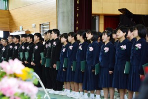 涙をこらえて最後の合唱に臨む卒業生＝１６日、奄美市名瀬の金久中学校