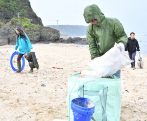  佐仁海岸で漂着ごみを回収する参加者たち＝７日、奄美市笠利町