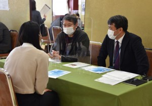 来場者に事業内容などを説明する事業所の担当者＝５日、奄美市名瀬