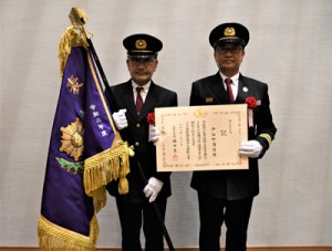 消防庁長官表彰で表彰旗が授与された伊仙著消防団の樺山団長（右）と佐倉功一副団長＝２７日、鹿児島市