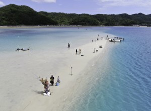 姿を現した「かくれ浜」で海遊びする住民ら＝２８日、奄美市笠利町の喜瀬沖（本社小型無人機で撮影）