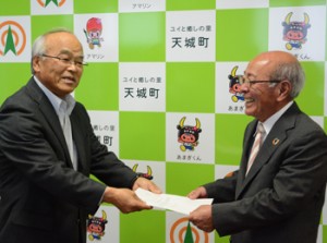 交付式で森田町長（右）から目録を受け取る中原施設長＝２２日、天城町役場