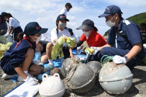 拾い集めた漂着ごみを分類する生徒ら＝２８日、龍郷町嘉渡 