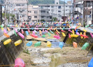 新川に掲げられた約１０００匹のこいのぼり＝２５日、奄美市名瀬