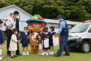 警察官から防犯グッズを手渡される新入生児童＝６日、宇検村の田検小学校