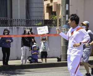 沿道の家族に笑顔を見せる深美さん＝２７日、奄美市名瀬