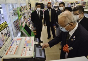 コンビニのマルチコピー機で住民票の写しを発行する竹田町長＝１日、龍郷町浦